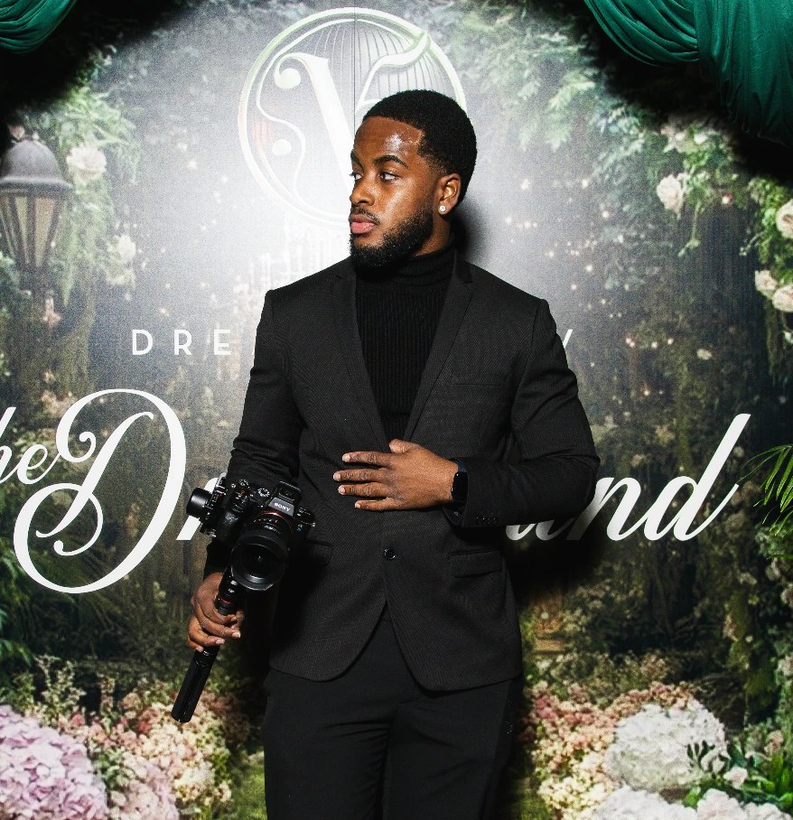 Qu with a camera on a red carpet